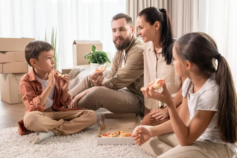 Friendly family eating pizza in new house
