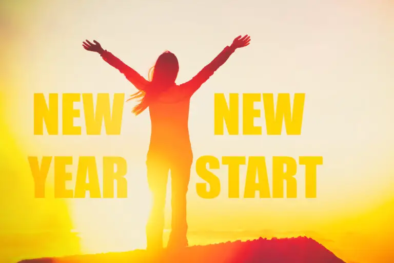 New Year New Start success winner concept happy woman motivation inspirational quote on silhouette person in sunset with arms up in confidence. You can start to change your life