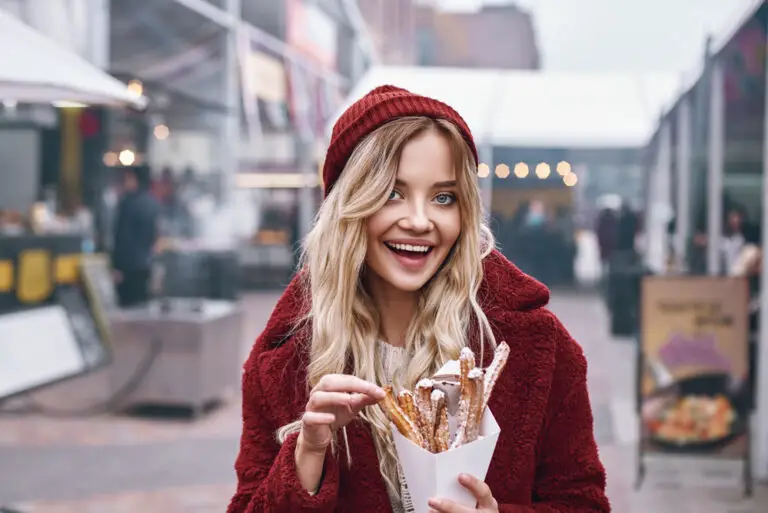 Close-up of young blonde woman eatting churros