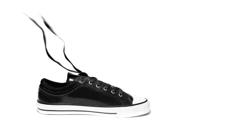 Close-up of black sneaker shoe on white background with copy space