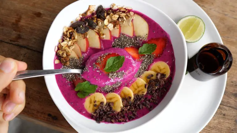 Top view of a spoon in dragon fruit smoothie bowl